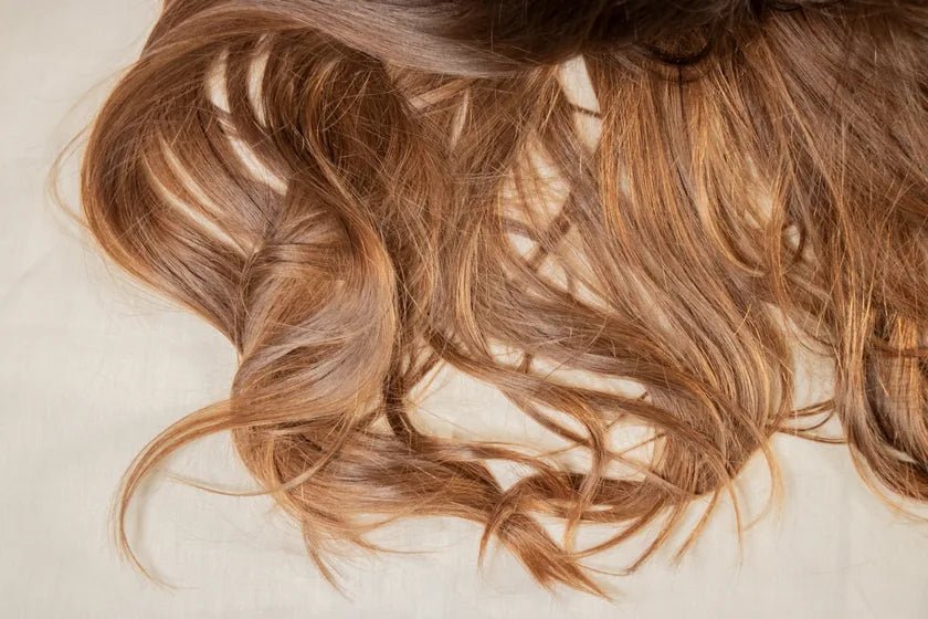 Soft auburn waves spread across pale linen