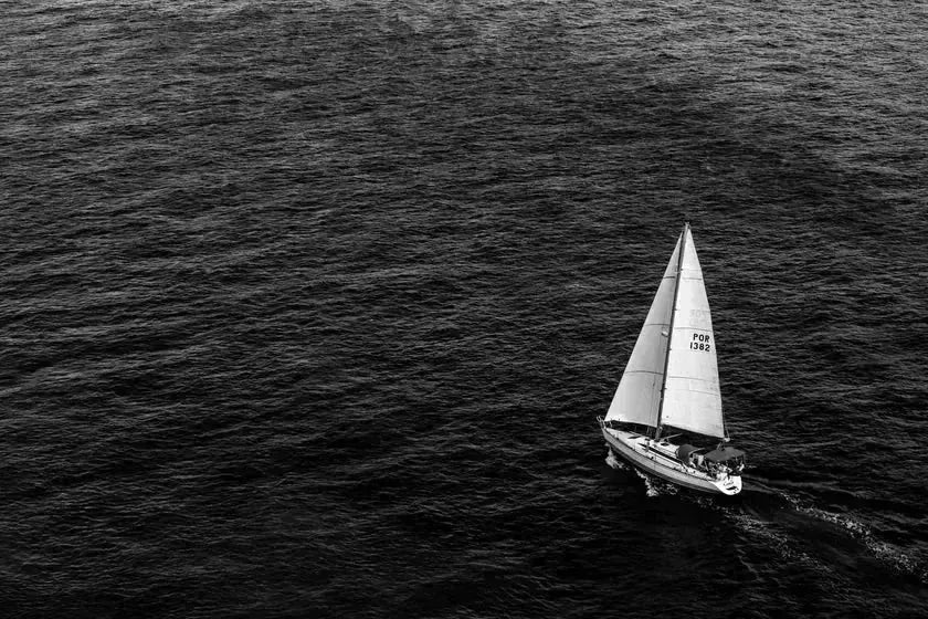 A lone sailing boat on open grey water — the pared-back, considered spirit Meera Capsule brings to a father's routine