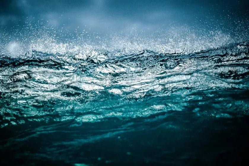 Deep teal sea rising under a heavier sky as the season turns